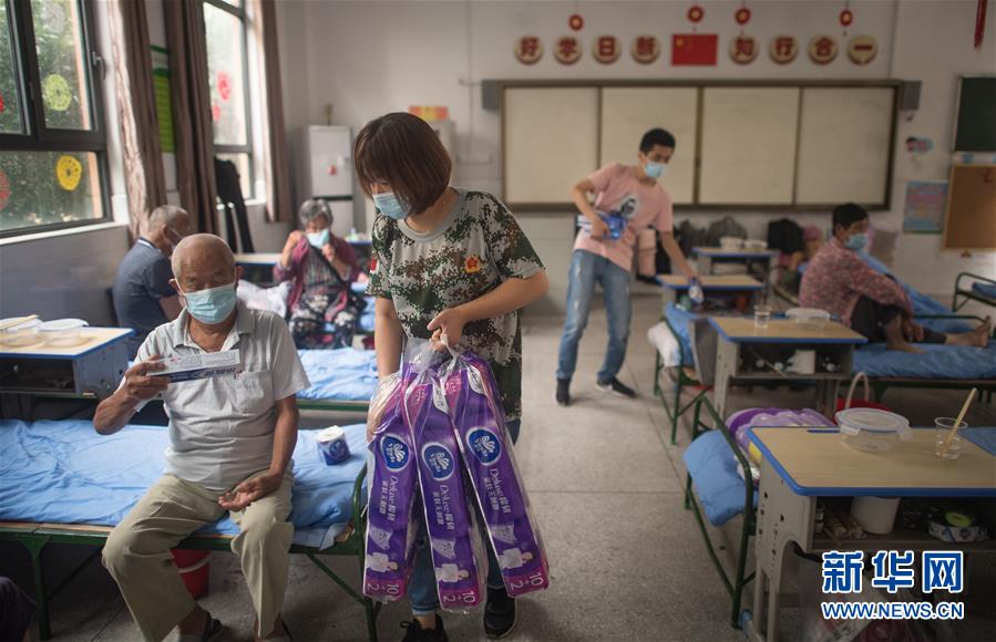 7月7日，在武汉街道口小学东方雅园分校安置点，工作人员为天兴乡村民发放生活物资。新华社记者 肖艺九 摄